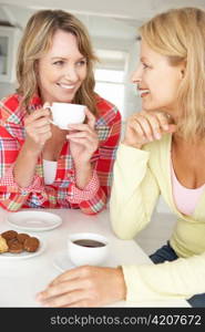 Mid age women chatting over coffee at home