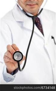 Mid section of a male doctor in lab coat holding a stethoscope. Focus on the stethoscope.