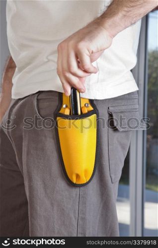 Mid section of man holding his tool pouch