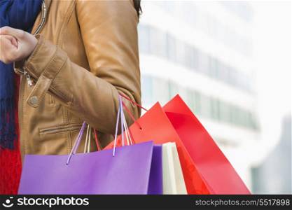 Mid section of woman carrying shopping bags