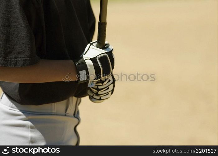Mid section view of a boy holding a baseball bat