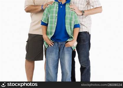 Mid section view of a boy standing with his father and grandfather