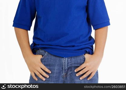 Mid section view of a boy standing with his hands in his pockets