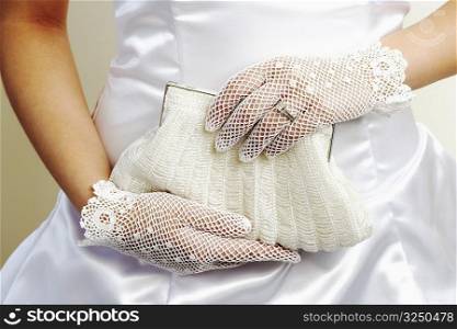Mid section view of a bride holding a purse