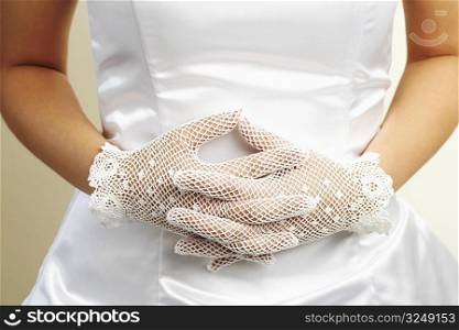 Mid section view of a bride wearing a pair of formal gloves