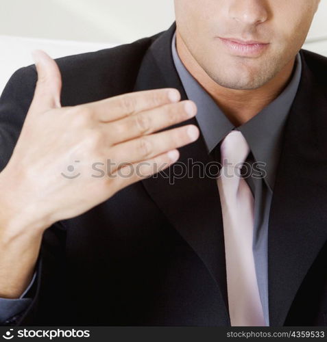 Mid section view of a businessman gesturing with his hand