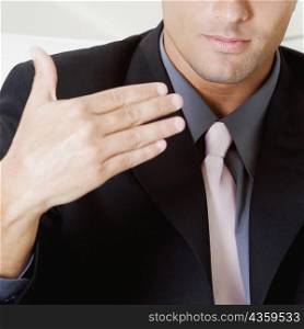 Mid section view of a businessman gesturing with his hand