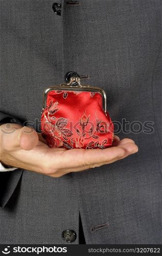 Mid section view of a businessman holding a change purse