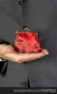 Mid section view of a businessman holding a change purse