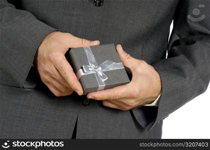 Mid section view of a businessman holding a gift