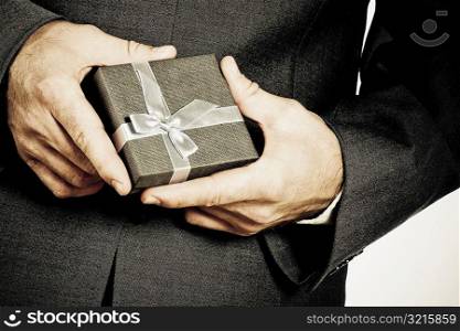Mid section view of a businessman holding a gift