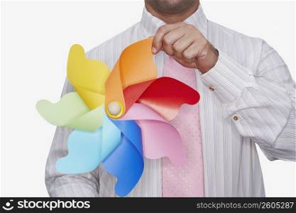 Mid section view of a businessman holding a pinwheel