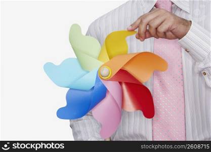 Mid section view of a businessman holding a pinwheel