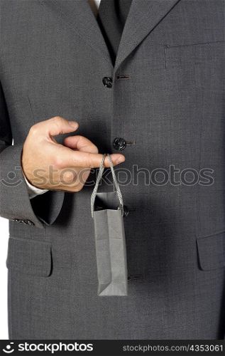 Mid section view of a businessman holding a shopping bag