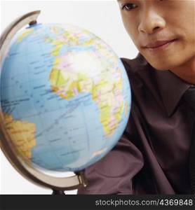 Mid section view of a businessman looking at a globe