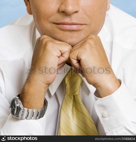 Mid section view of a businessman thinking with his hands under his chin