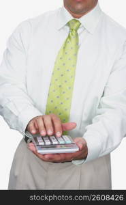 Mid section view of a businessman using a calculator