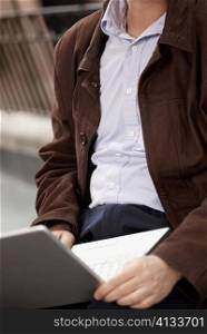Mid section view of a businessman using a laptop