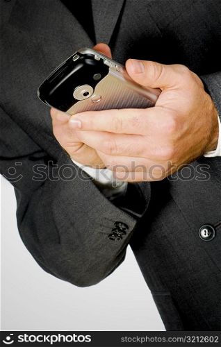 Mid section view of a businessman using a personal data assistant