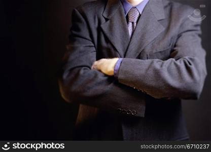 Mid section view of a businessman with his arms folded