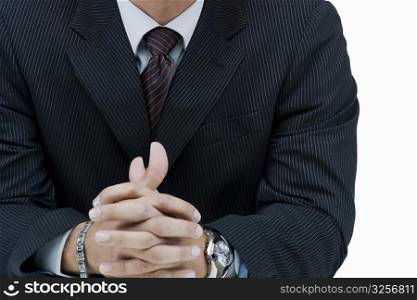 Mid section view of a businessman with his hands clasped