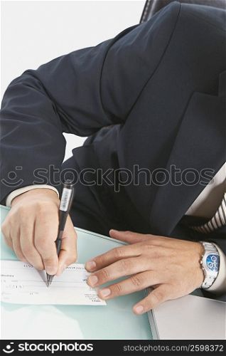 Mid section view of a businessman writing a check