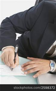 Mid section view of a businessman writing a check