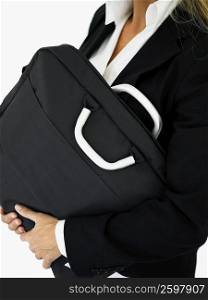 Mid section view of a businesswoman carrying a bag