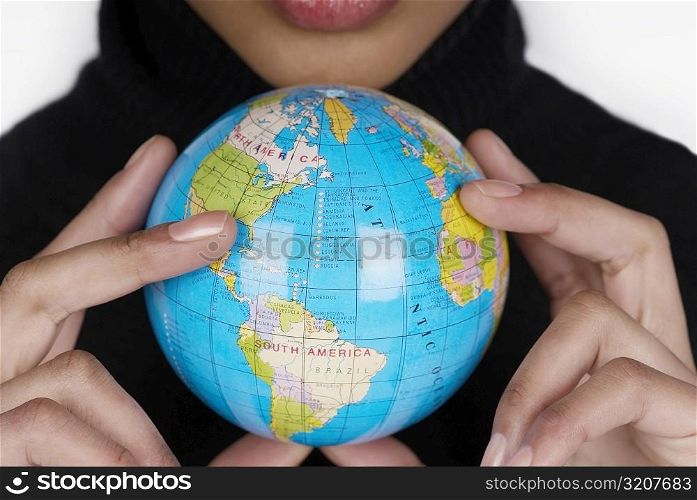Mid section view of a businesswoman holding a globe
