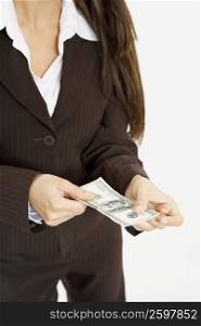Mid section view of a businesswoman holding American paper currency