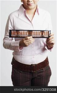 Mid section view of a businesswoman holding an abacus