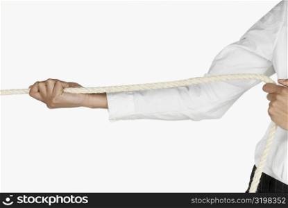 Mid section view of a businesswoman pulling a rope