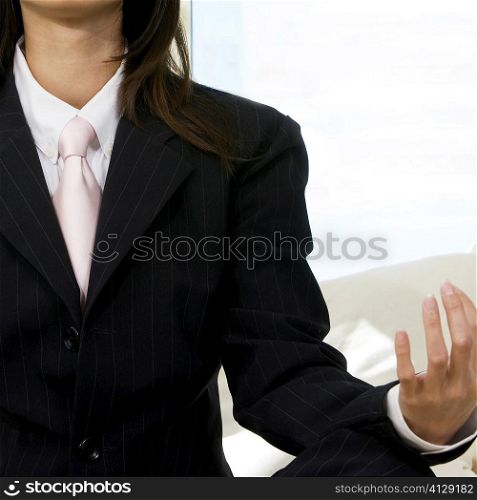 Mid section view of a businesswoman sitting in the lotus position