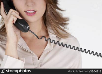 Mid section view of a businesswoman talking on the telephone