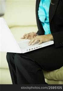Mid section view of a businesswoman using a laptop