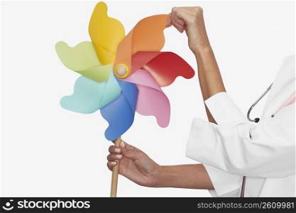 Mid section view of a female doctor holding a pinwheel