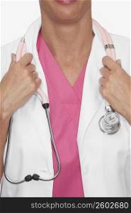 Mid section view of a female doctor holding a stethoscope around her neck