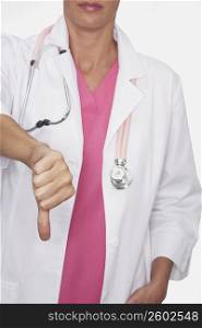 Mid section view of a female doctor showing a thumbs down sign
