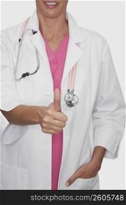 Mid section view of a female doctor showing a thumbs up sign