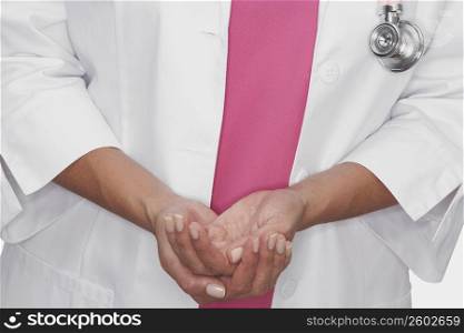 Mid section view of a female doctor with her hands cupped