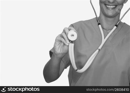 Mid section view of a female nurse holding a stethoscope