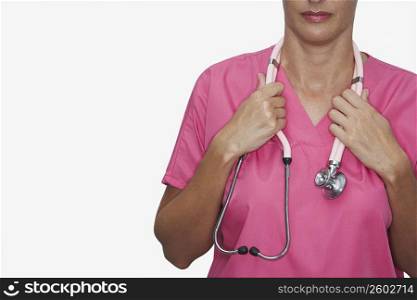 Mid section view of a female nurse holding a stethoscope around her neck