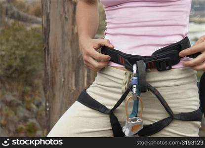 Mid section view of a female rock climber wearing harness