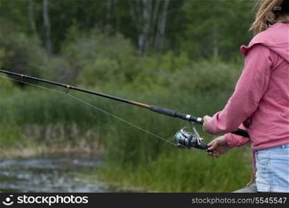 Mid section view of a girl fishing, Riding Mountain National Park, Manitoba, Canada