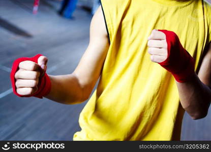 Mid section view of a male boxer wearing bandage in his both hands
