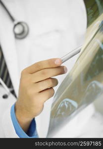 Mid section view of a male doctor examining an X-Ray