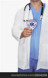 Mid section view of a male doctor holding a badge