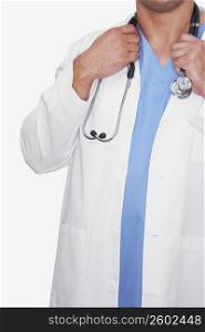 Mid section view of a male doctor holding a stethoscope around his neck