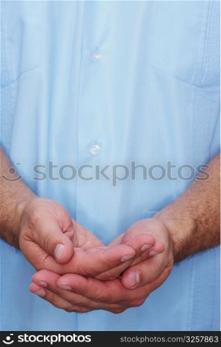 Mid section view of a male nurse cupping his hands