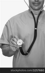 Mid section view of a male nurse holding a stethoscope
